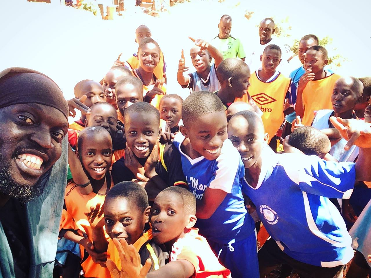 Children and youth in sports jerseys smiling together outdoors