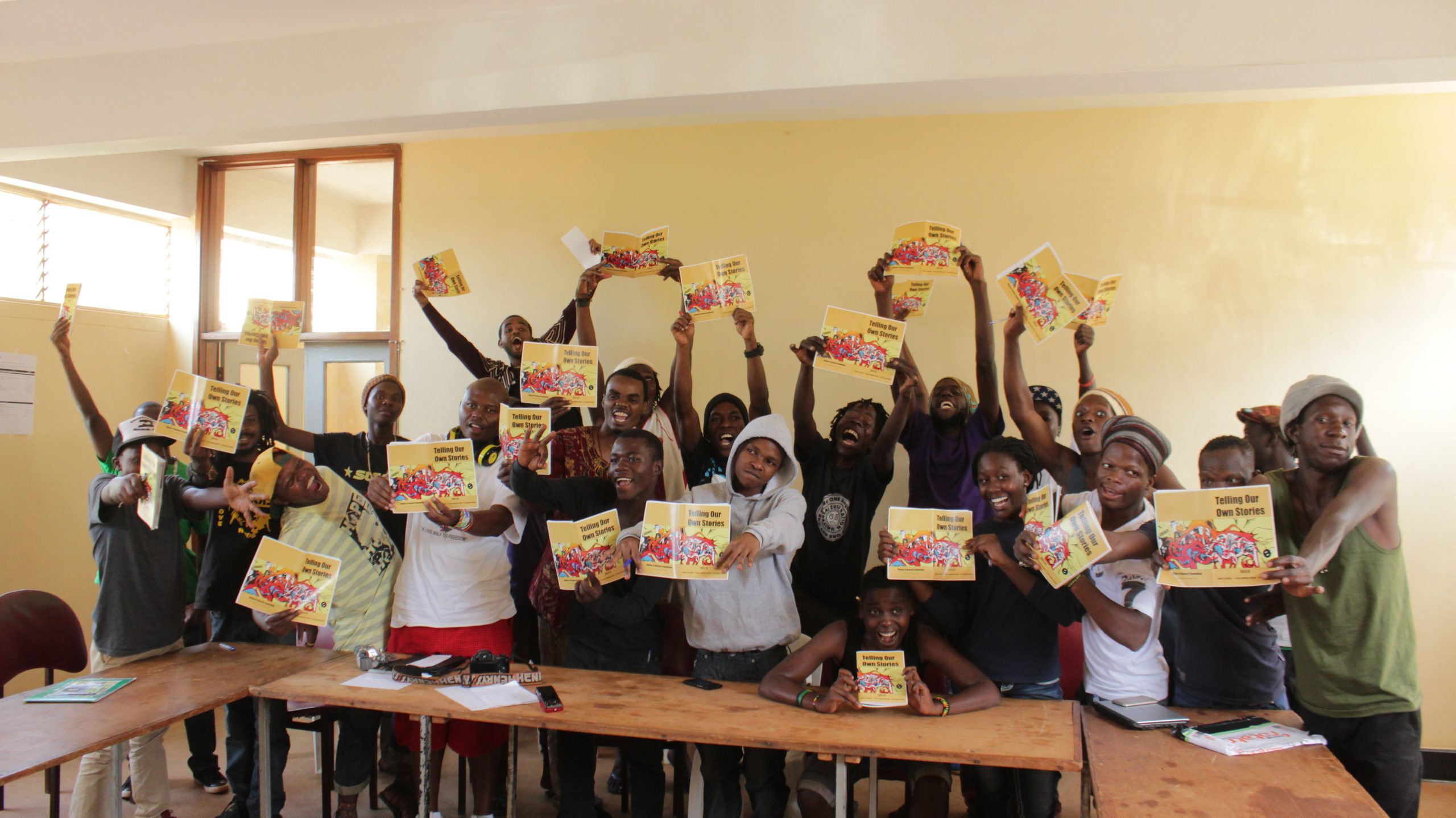 A group holding up copies of a publication together
