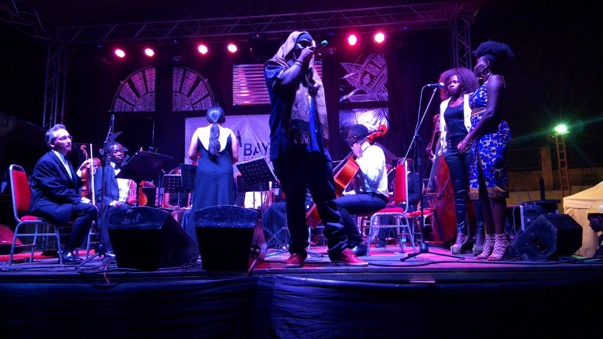 Musicians performing percussion on a lit stage